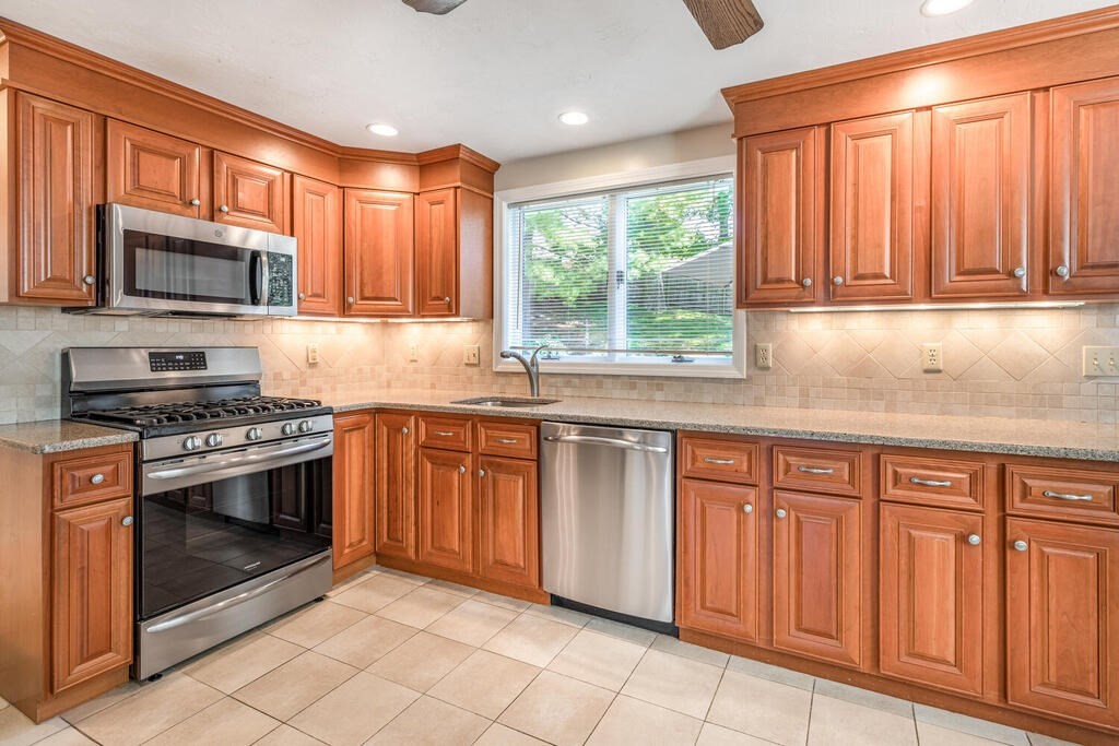 172 Virginia Road Waltham, MA 02453 - Photo 9 of 26 a kitchen with stainless steel appliances granite countertop a stove a sink and a microwave