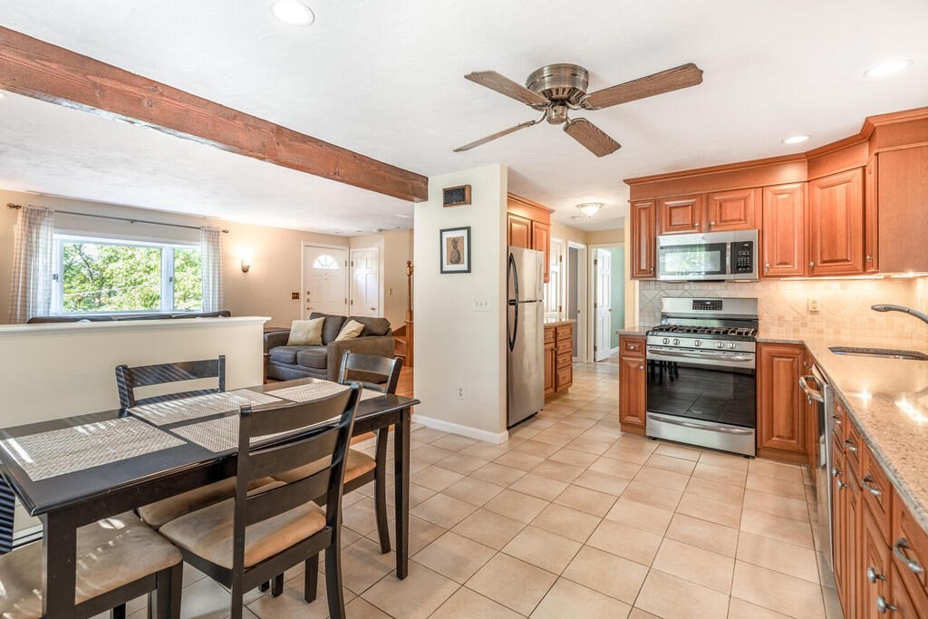 172 Virginia Road Waltham, MA 02453 - Photo 10 of 26 a kitchen with stainless steel appliances kitchen island granite countertop a refrigerator a stove a sink dishwasher and a stove with a dining table