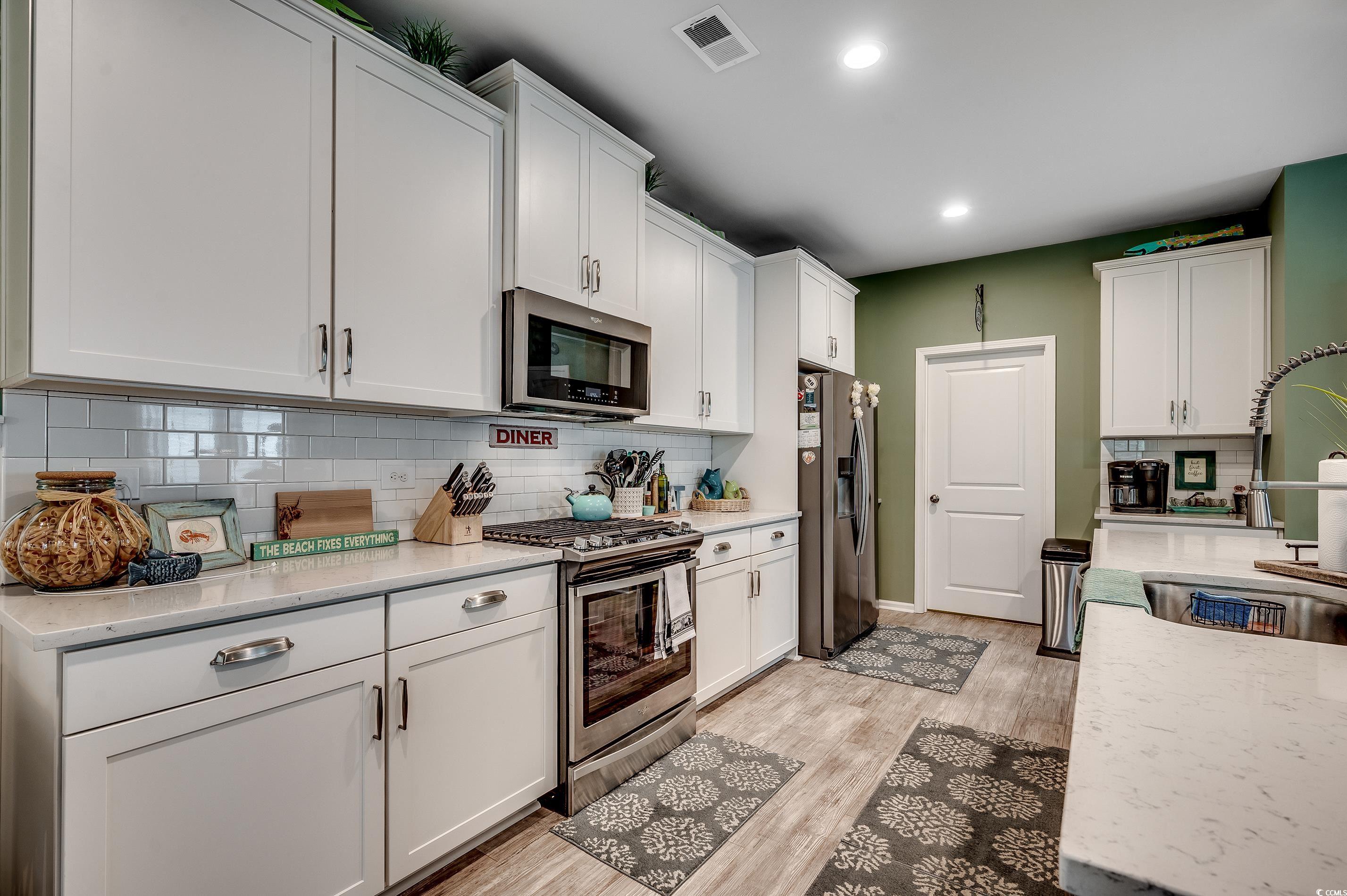 205 Splendor Circle Murrells Inlet, SC 29576 - Photo 7 of 40 Kitchen with visible vents, white cabinets, a sink