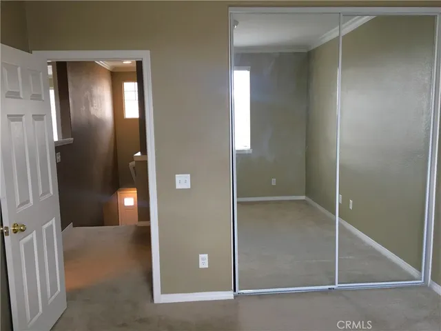 an empty room with closet and mirror