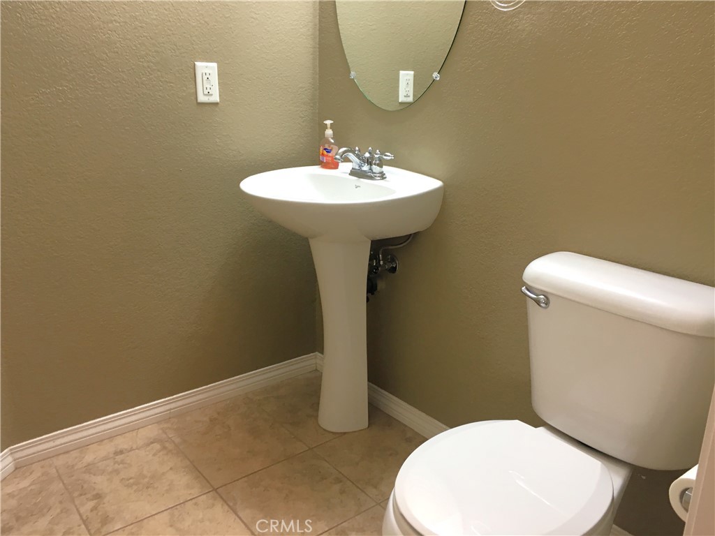 15213 Hawk Street Fontana, CA 92336 - Photo 6 of 20 a bathroom with a sink a toilet and a mirror