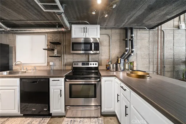 a kitchen with stainless steel appliances kitchen island granite countertop a sink stove and refrigerator