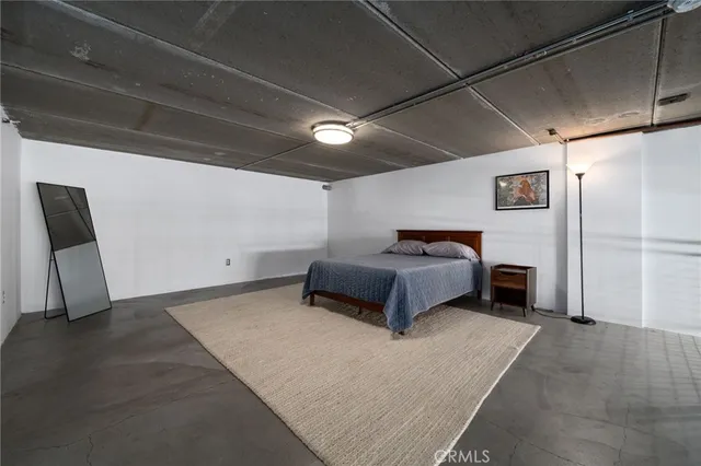 a spacious bedroom with a bed and a chair