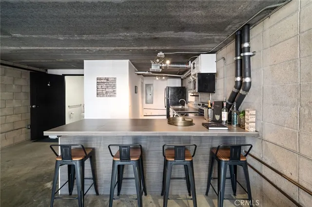 a kitchen with stainless steel appliances a table and chairs in it