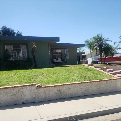a view of a house with a yard and a large parking space