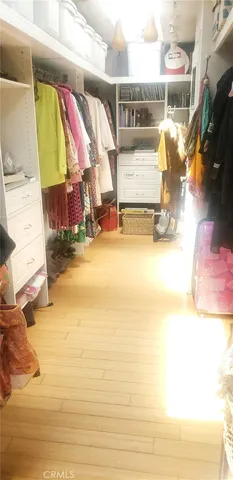 a view of walk in closet with clothes and shoes