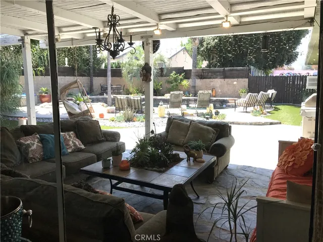 a living room with patio furniture and a potted plant