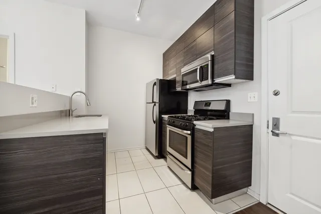 a kitchen with stainless steel appliances granite countertop a sink and a stove