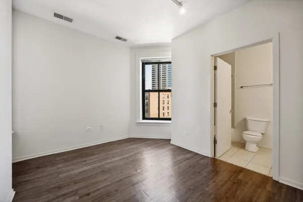 a view of a room with wooden floor and a toilet