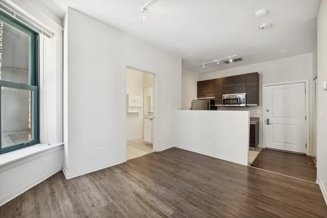 a view of a livingroom with wooden floor and a flat screen tv