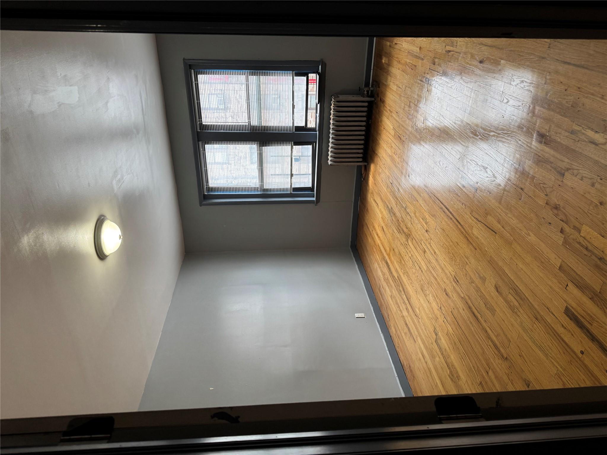 2922 Barnes Avenue, Unit 3A Bronx, NY 10467 - Photo 5 of 12 Spare room featuring radiator heating unit and hardwood / wood-style flooring