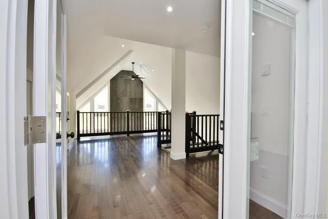 a view of a hallway with wooden floor and a window