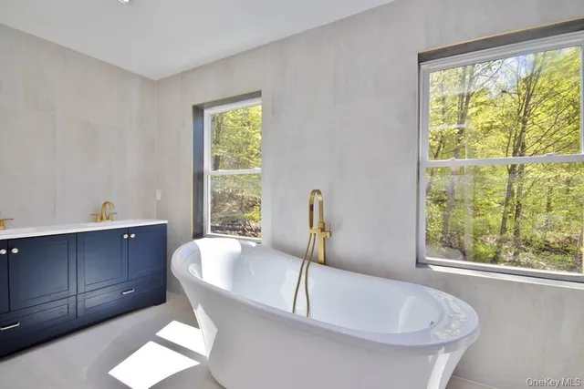 a white bath tub sitting in a bathroom next to a window