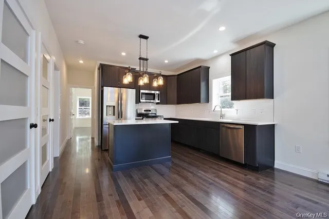 a large kitchen with stainless steel appliances kitchen island granite countertop a large counter top a sink refrigerator and cabinets