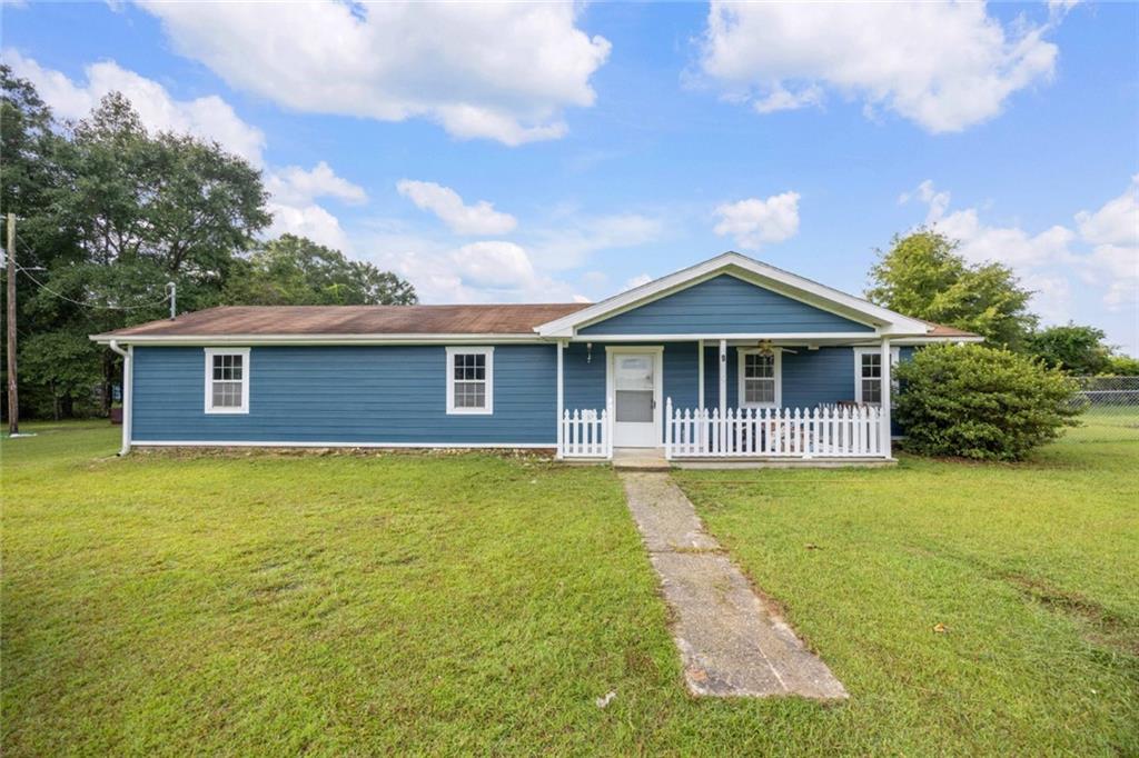 9 Spies Road Fort Mitchell, AL 36856 - Photo 1 of 23 Blue siding exterior with white trim, a covered front porch, and a white picket fence