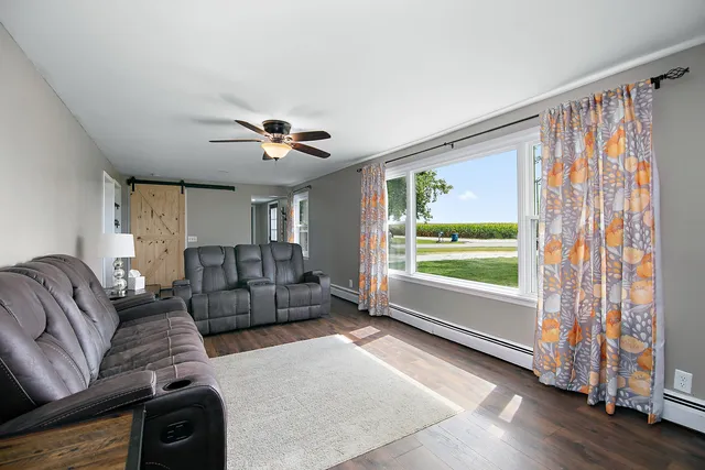 a living room with furniture and a large window with wooden floor