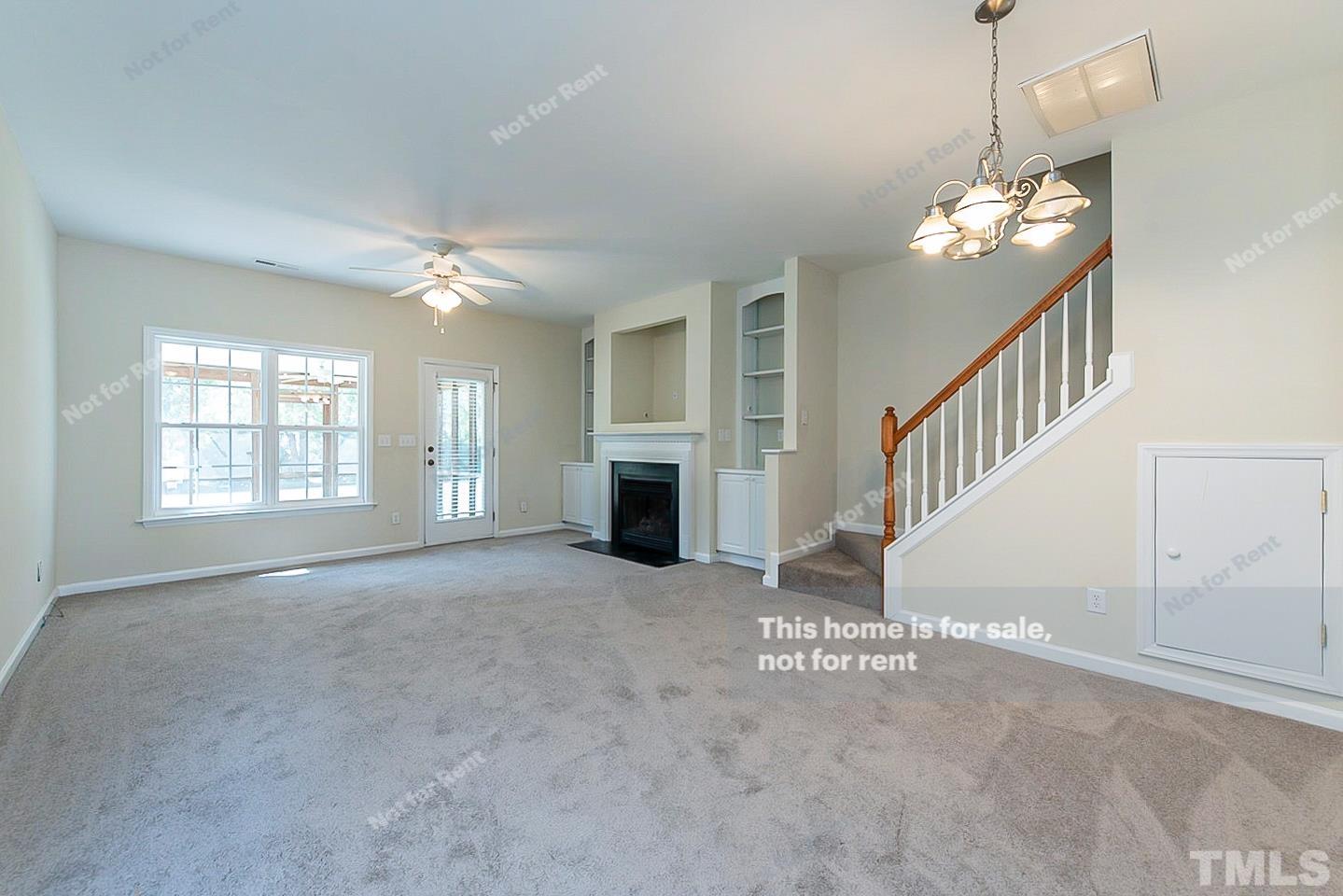 2109 Metacomet Way Raleigh, NC 27604 - Photo 4 of 17 a view of an empty room with chandelier fan and fireplace