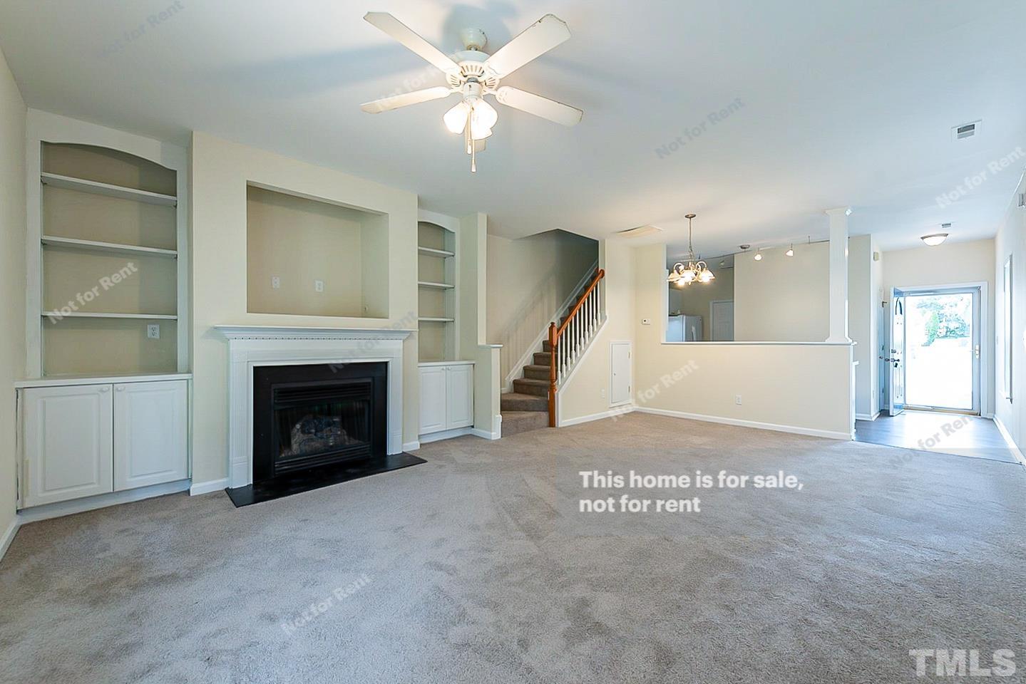 2109 Metacomet Way Raleigh, NC 27604 - Photo 5 of 17 a view of a livingroom with a fireplace a ceiling fan and windows
