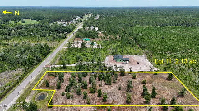 an aerial view of residential houses with outdoor space and trees