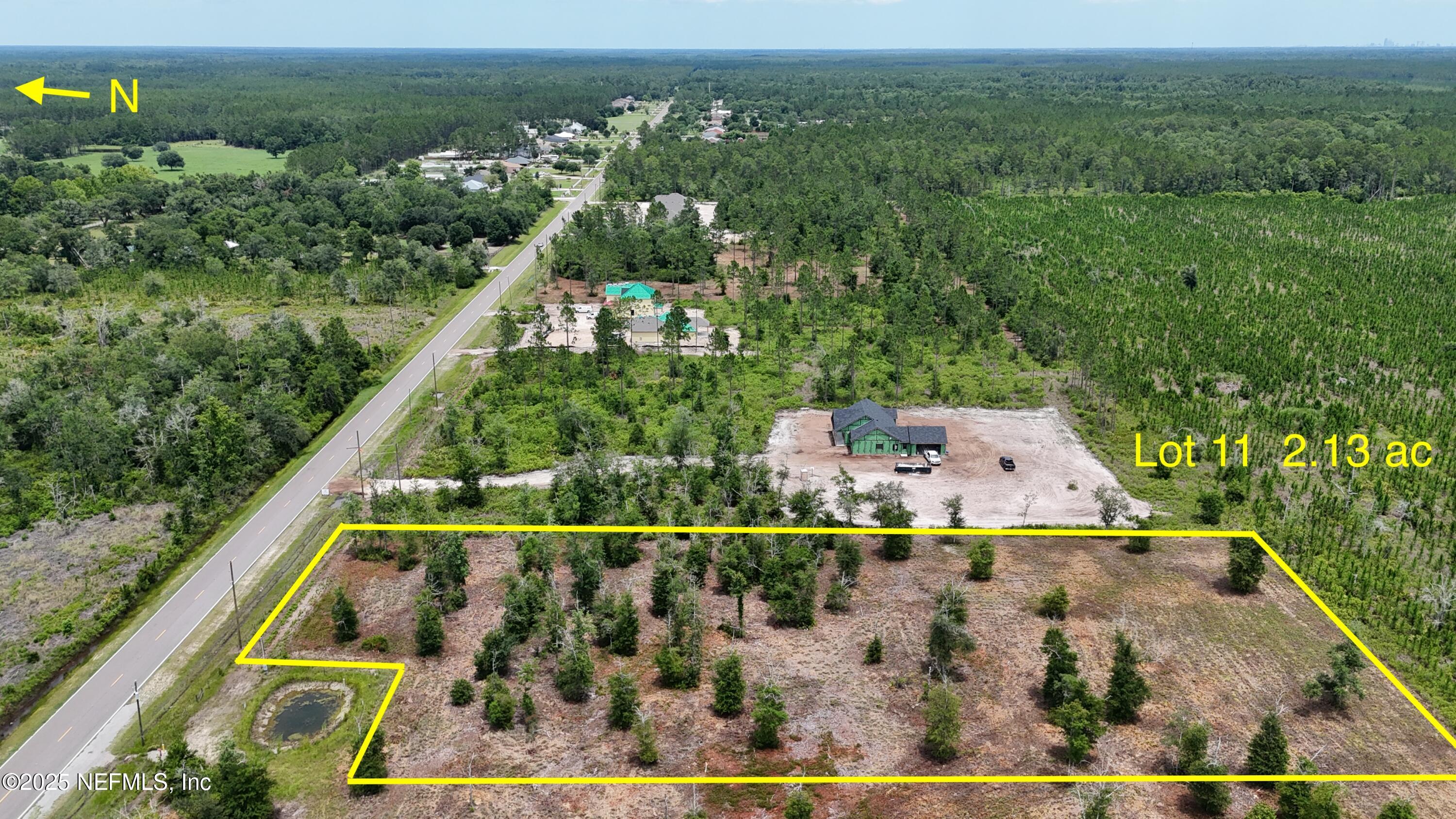an aerial view of residential houses with outdoor space and trees