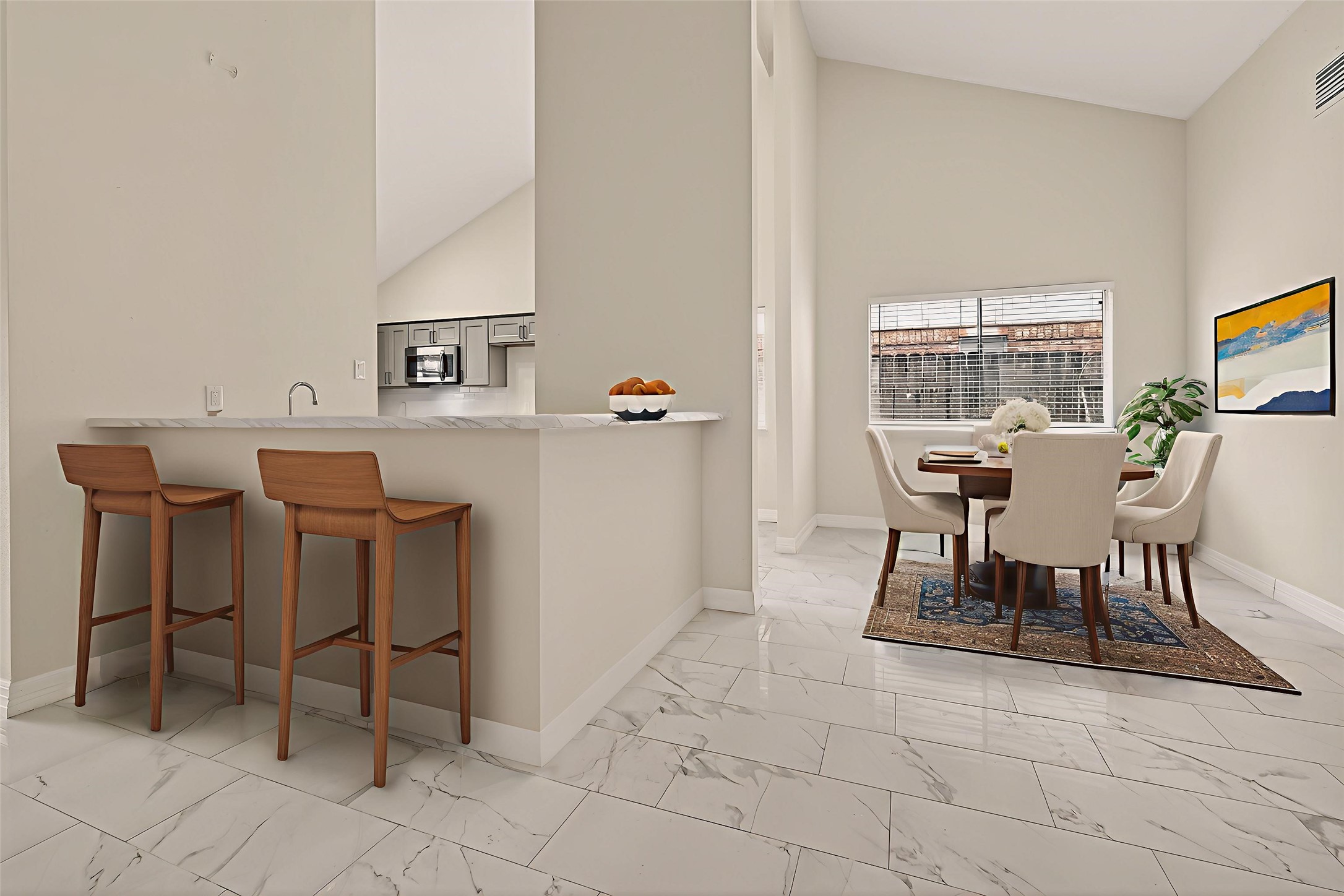 7027 Dickson Way Missouri City, TX 77489 - Photo 4 of 22 Bright and modern open-plan space with a kitchen and dining area. Features a marble-tiled floor, breakfast bar with two wooden stools, and a cozy dining setup. Large window provides natural light, highlighting the neutral tones and elegant decor.