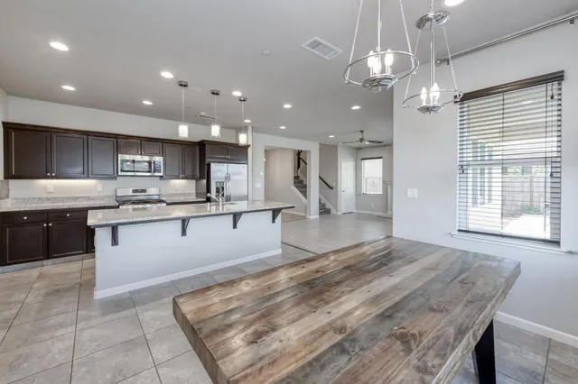 a large kitchen with kitchen island a sink stainless steel appliances and cabinets