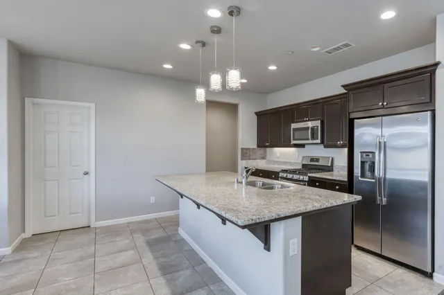 a kitchen with kitchen island a counter top space appliances and cabinets