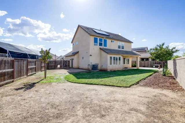 a view of a big house with a big yard and large trees