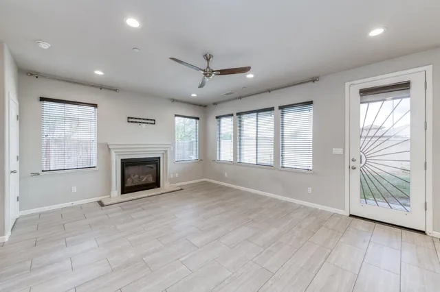 an empty room with windows and fireplace