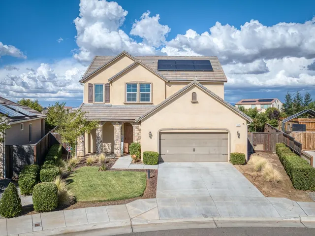 a view of a white house next to a yard