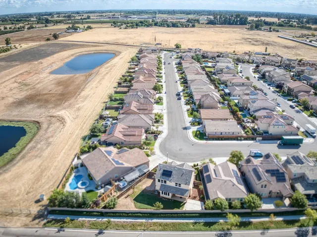 an aerial view of residential houses with outdoor space and lake view