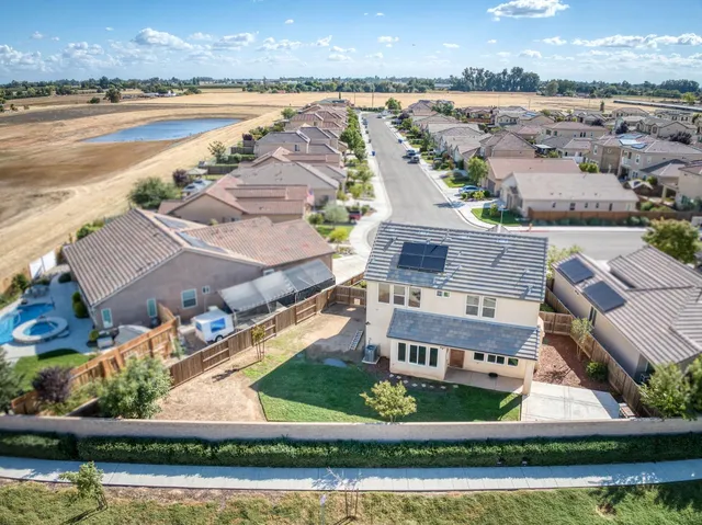 an aerial view of residential houses with outdoor space and swimming pool