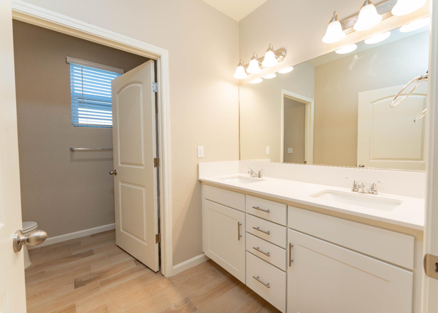 30480 Bellwood Road Visalia, CA 93291 - Photo 31 of 37 a bathroom with a double vanity sink and a mirror