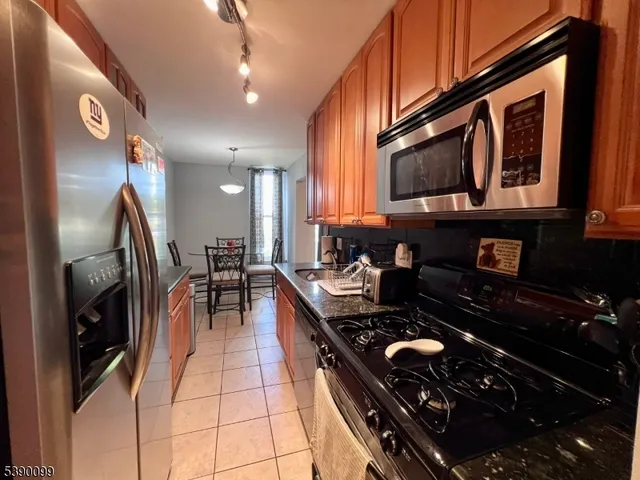 a kitchen with stainless steel appliances granite countertop a stove and a microwave