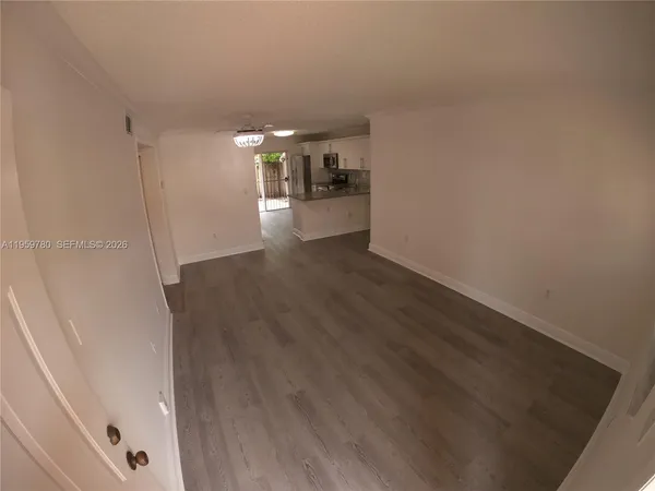 a view of a hallway with wooden floor and a cabinet