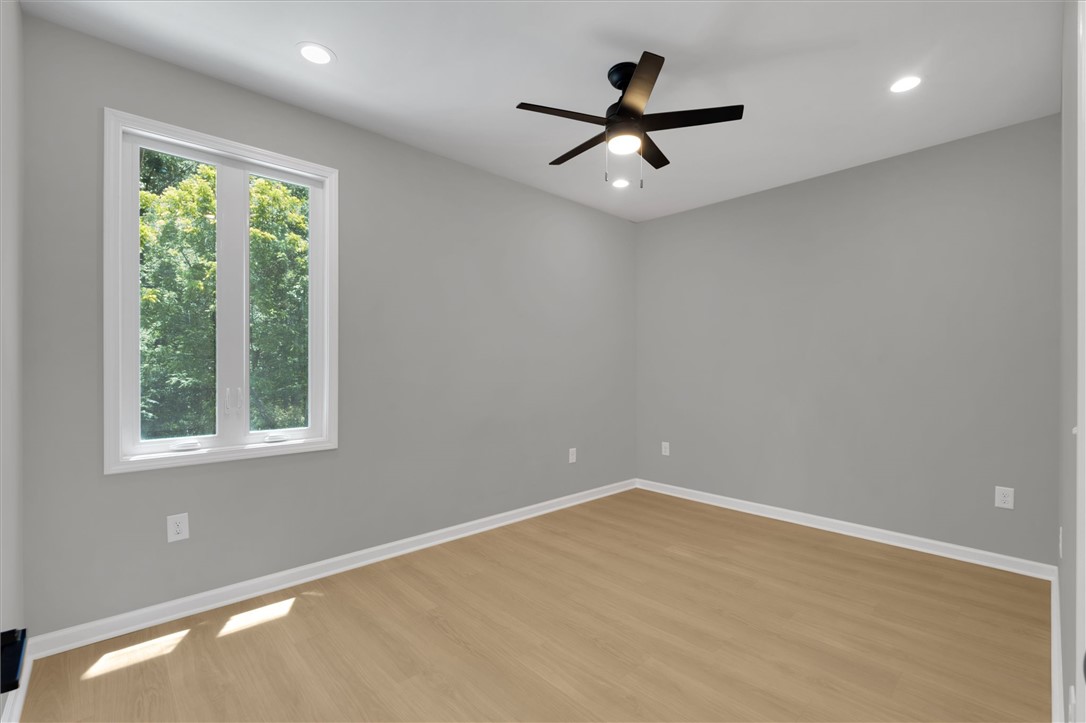 159 Cherokee Trail Easley, SC 29640 - Photo 23 of 38 A window-filled room with light hardwood flooring and modern ceiling fan provides a calm setting.