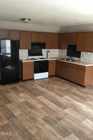 a kitchen with stainless steel appliances kitchen island granite countertop a stove a sink and a refrigerator