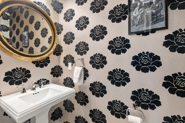 a bathroom with a sink and mirror with bathtub