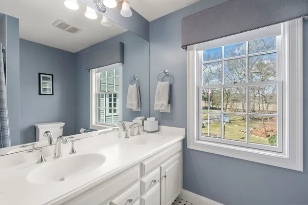 a bathroom with double vanity and a mirror