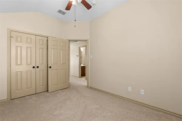 an empty room with chandelier fan
