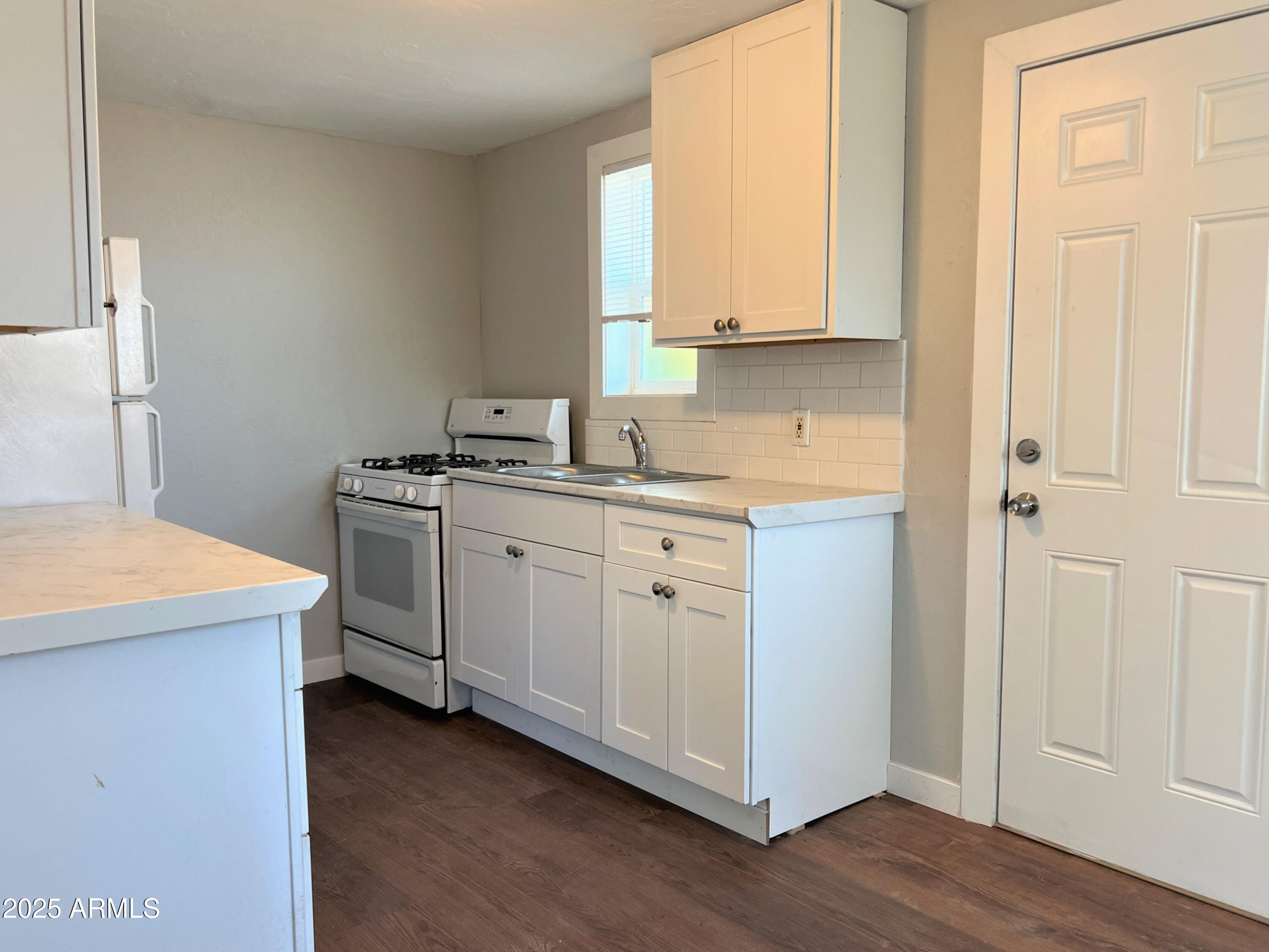 1125 East Devonshire Avenue, Unit 9 Phoenix, AZ 85014 - Photo 3 of 11 a kitchen with a sink stove and cabinets