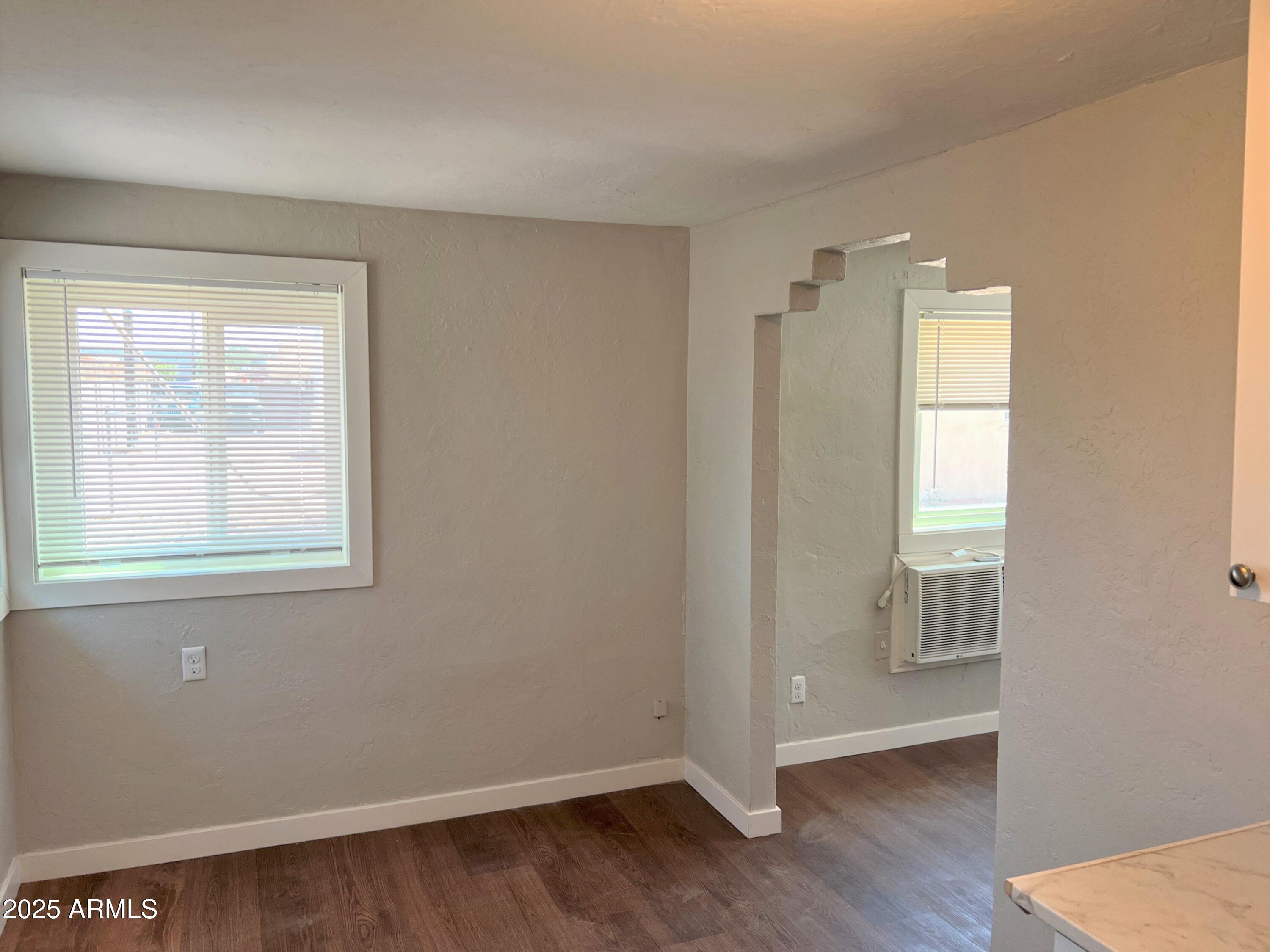 1125 East Devonshire Avenue, Unit 9 Phoenix, AZ 85014 - Photo 5 of 11 an empty room with wooden floor and windows
