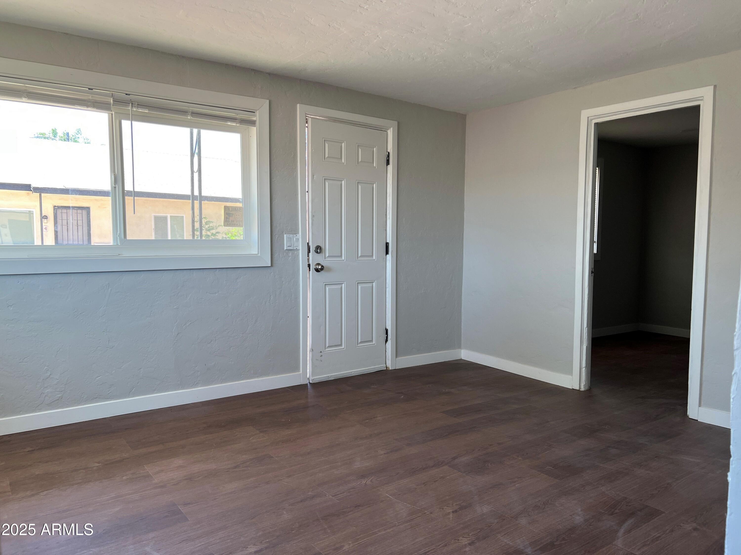 1125 East Devonshire Avenue, Unit 9 Phoenix, AZ 85014 - Photo 6 of 11 a view of an empty room with wooden floor and a window
