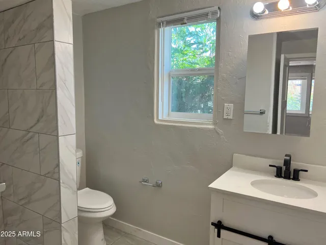 a bathroom with a white toilet sink and a mirror