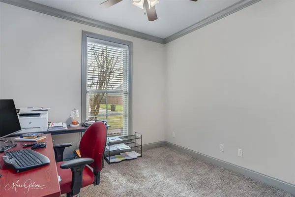 a view of a workspace with furniture and a window
