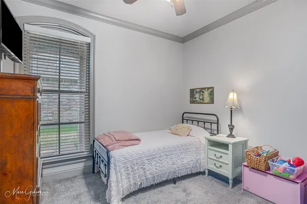 a bedroom with a bed and a flat tv screen on dresser