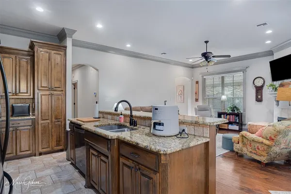 a kitchen with sink a refrigerator and chairs