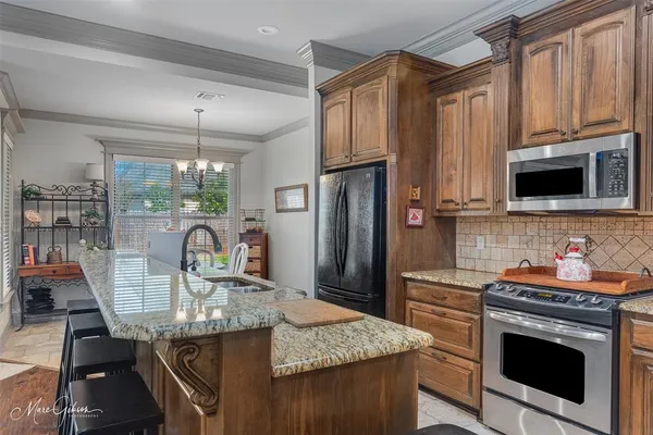 a kitchen with stainless steel appliances granite countertop a stove microwave and refrigerator