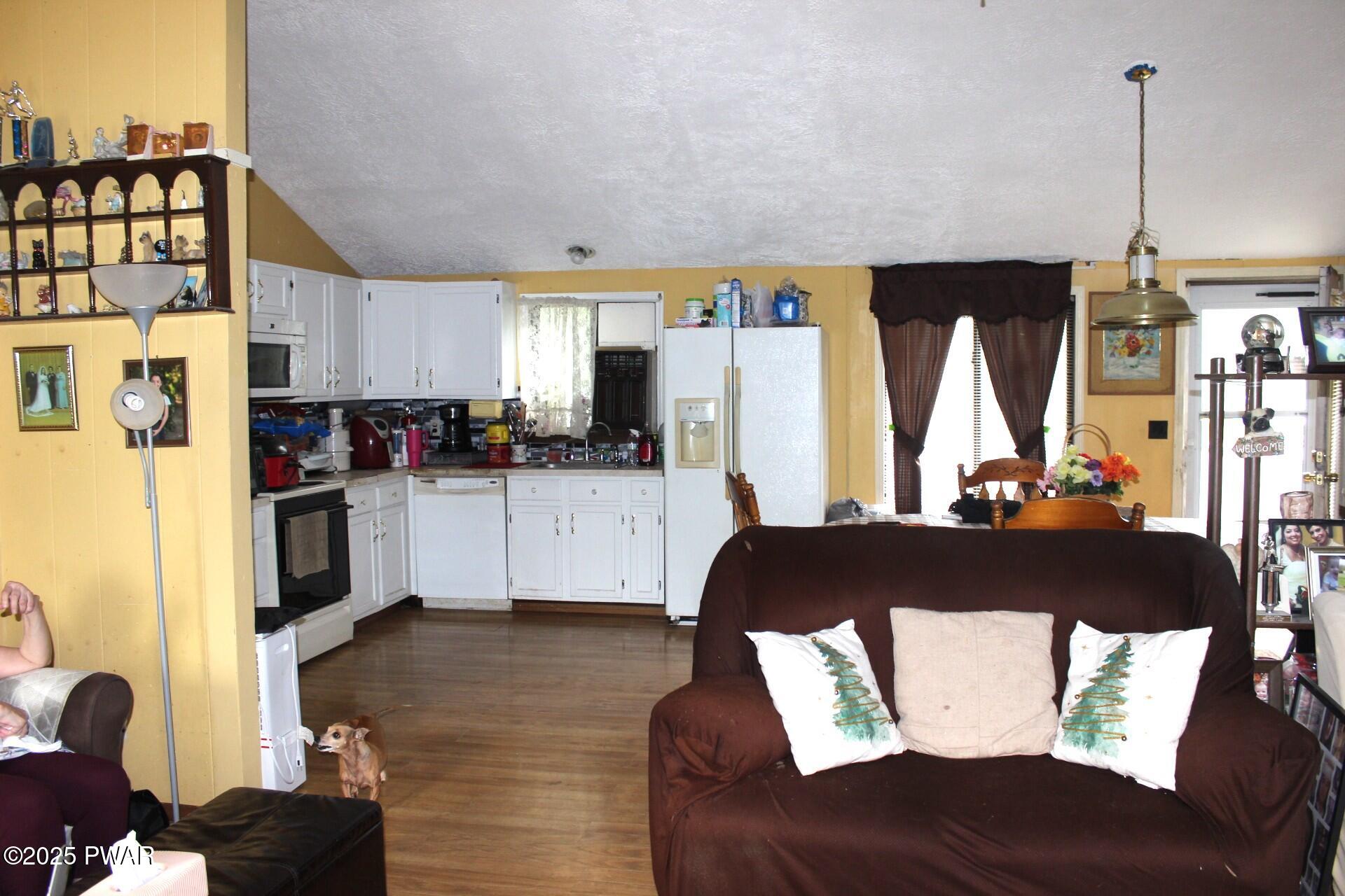 30 Brookfield Road, Unit LOT 1259 Lake Ariel, PA 18436 - Photo 4 of 32 a kitchen with stainless steel appliances kitchen island granite countertop a refrigerator a stove and a sink with wooden floor