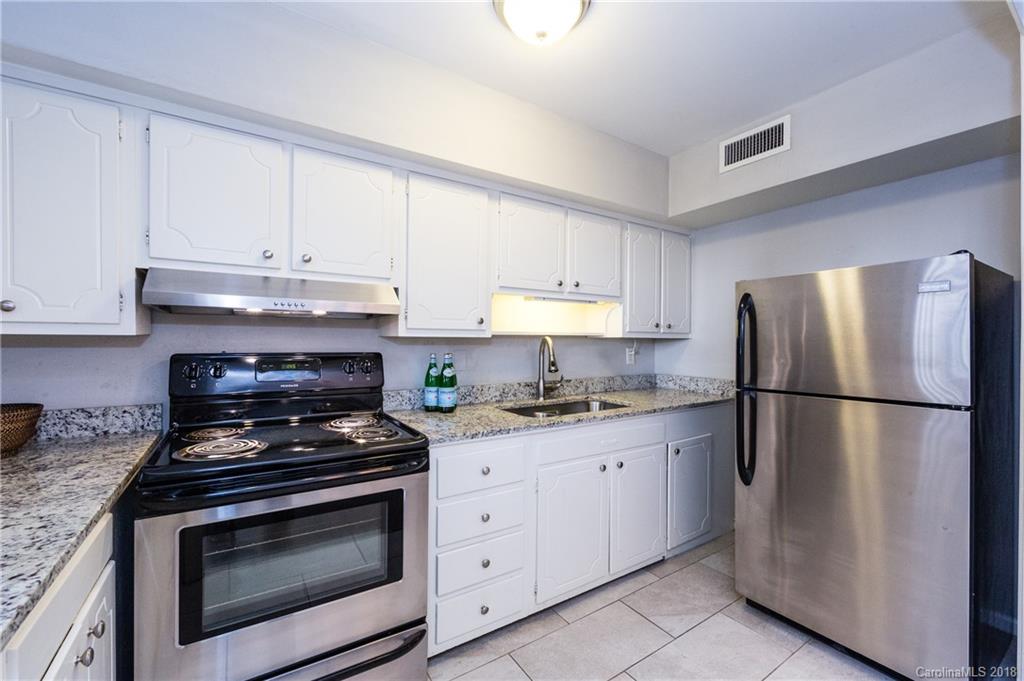 920 McAlway Road, Unit C Charlotte, NC 28211 - Photo 15 of 27 a kitchen with refrigerator a stove a sink and a counter space
